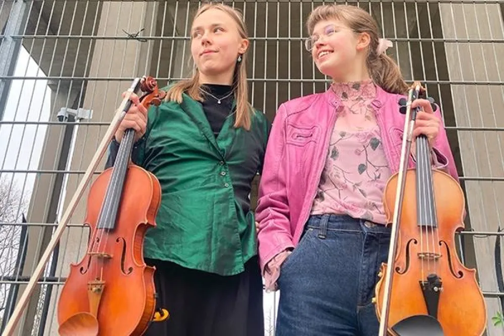 Tjejerna Elsa och Alma på foto. Två unga tjejer med en varsin fiol i handen.
