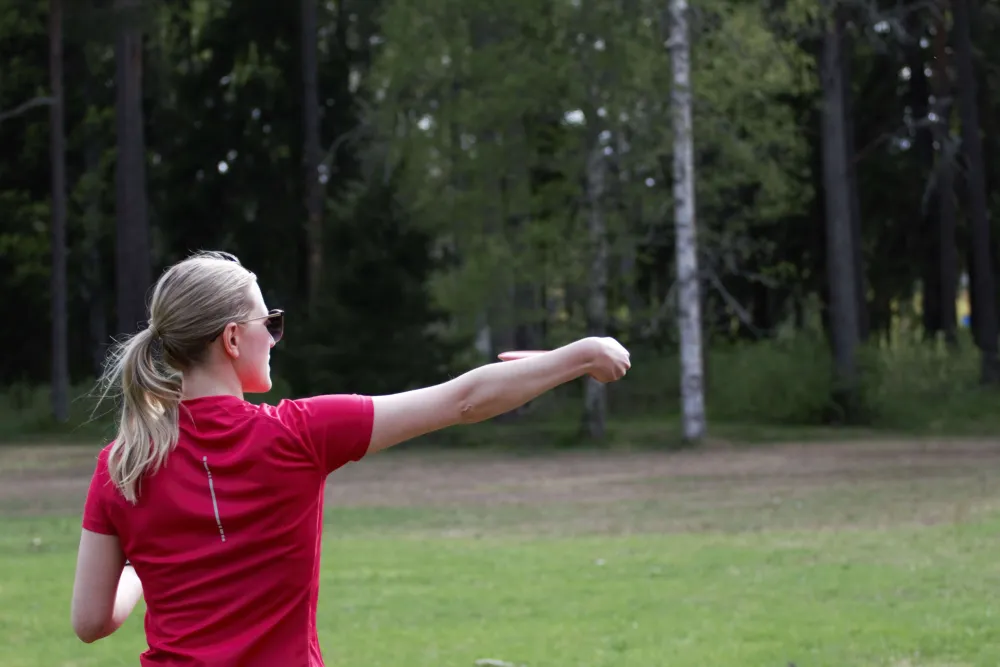 Kvinna som kastar frisbeedisc.